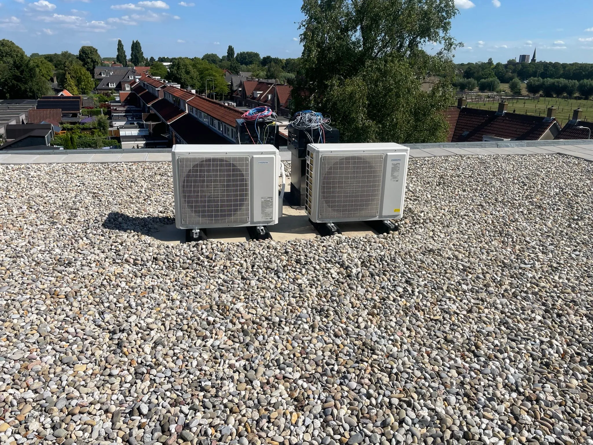 Twee airconditioning buitenunits op plat dak woongebouw door CKW Installatietechniek Moerkapelle